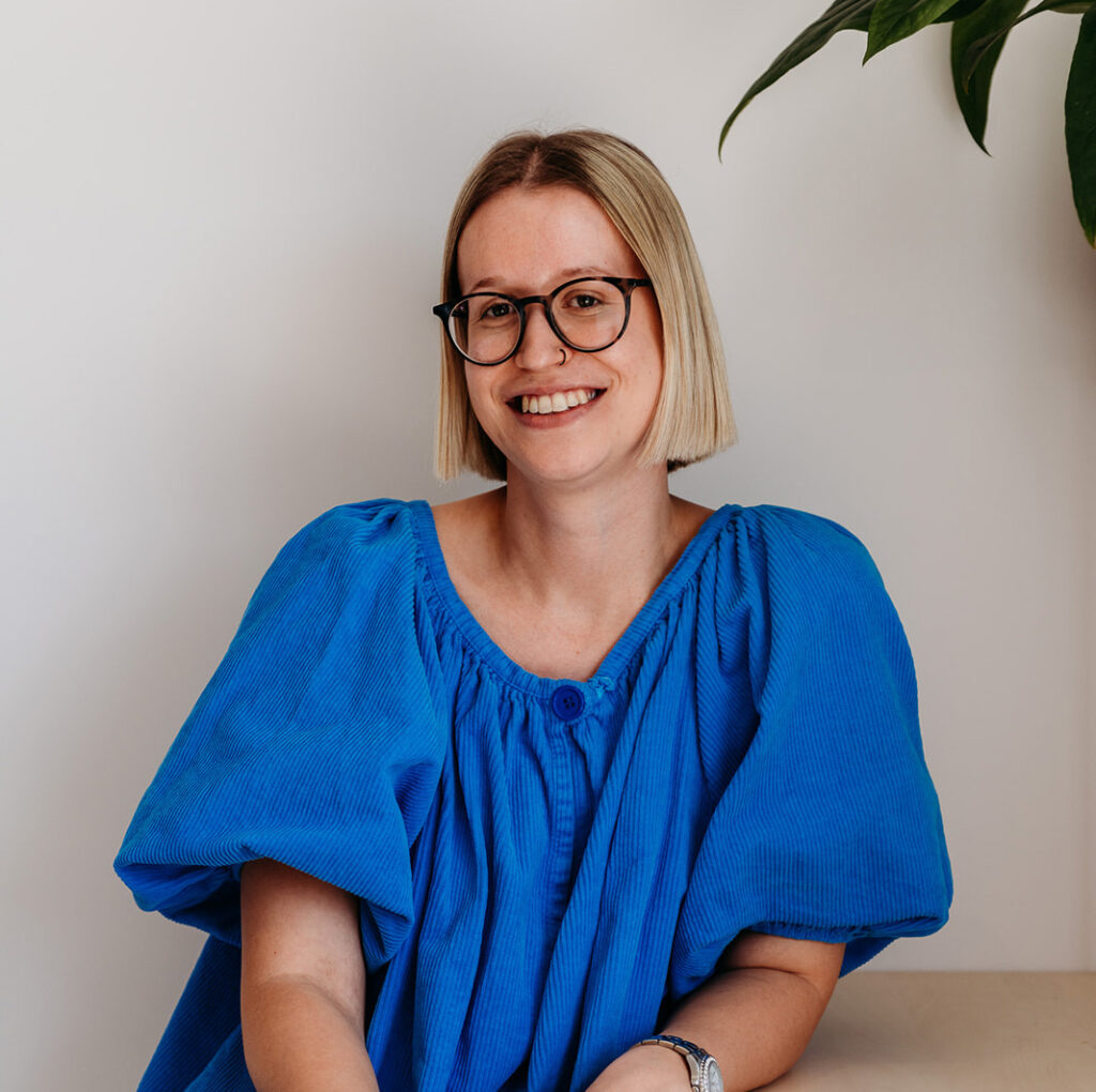 Maja D'haen, digital marketeer bij Uncoded, met bril, blond haar en blauwe bloes